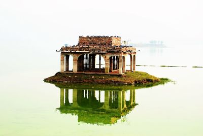 Reflection of built structure in water against sky