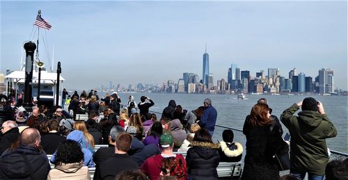 People looking at city buildings against sky