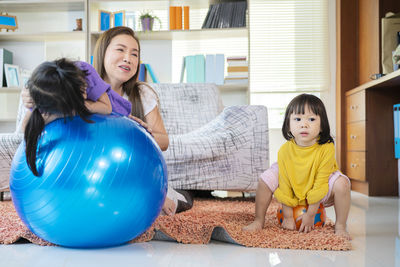 A mother, two asian daughters, happily playing at home, mother and daughter smiles,