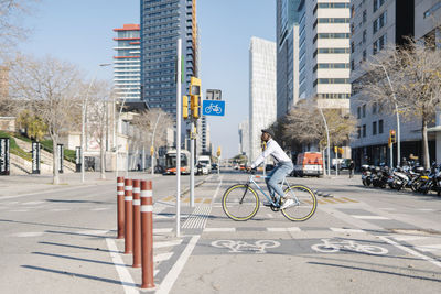 Young man with bicycle in parking lot on sunny day