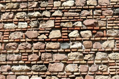 Full frame shot of stone wall during sunny day