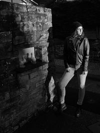 Full length of young man standing against wall