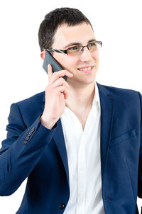 Young man using smart phone against white background