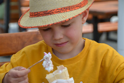 Close up image of boy hand holding fresh waffle cone with vanilla