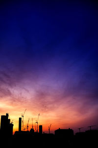 Silhouette buildings against sky during sunset