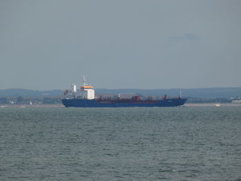 Ship sailing on sea against sky