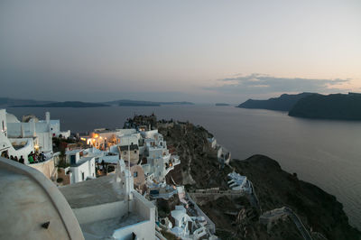 High angle view of houses on mountain by sea against sky during sunset