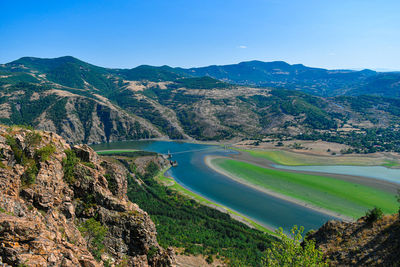 Scenic view of mountains and river against sky