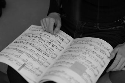 Midsection of person with sheet music