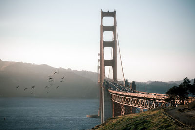 Suspension bridge over water against sky