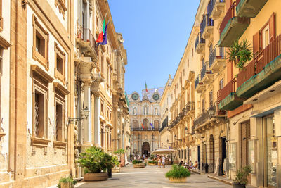 Street amidst buildings in town against sky