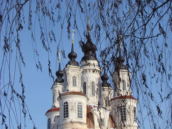 Low angle view of trees and building against sky