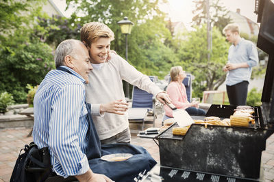 Father and son barbecuing at yard