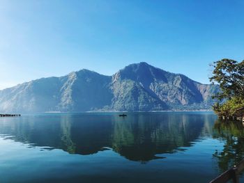 Scenic view of lake and mountains against blue sky