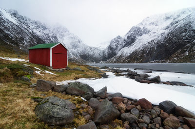 Scenic view of lake by snowcapped mountains against sky norway