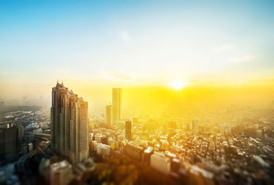 Modern buildings in city against sky during sunset