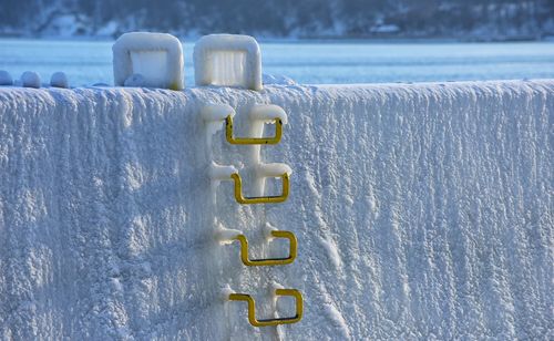 Close-up of metallic handles on snow covered wall