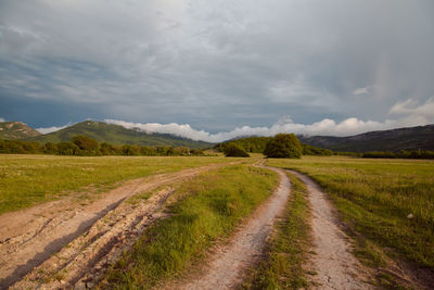 Dirt road along countryside landscape