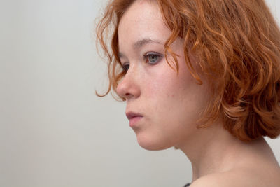 Close-up portrait of a young woman against white background