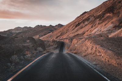 Road amidst mountains against sky