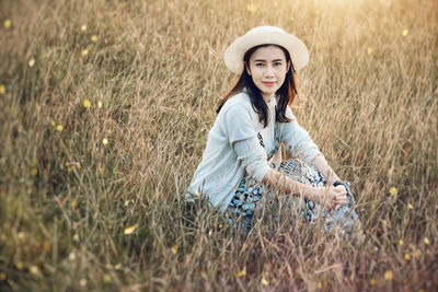 Portrait of mid adult woman relaxing on grassy field