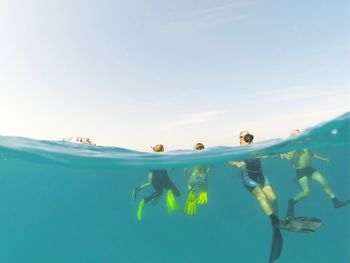 People snorkeling in sea against sky