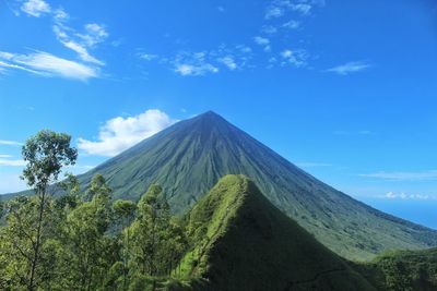 Panoramic view of volcanic mountain against blue sky