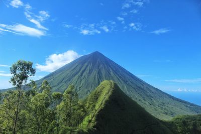 Panoramic view of volcanic mountain against blue sky