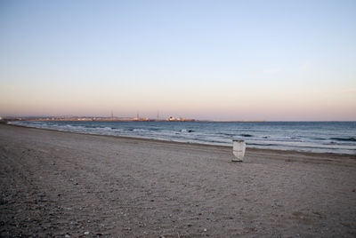 Scenic view of beach against clear sky during sunset