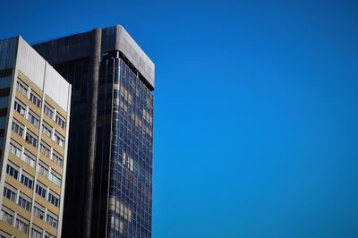 Low angle view of modern building against clear blue sky