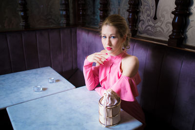 Portrait of woman sitting at table in restaurant