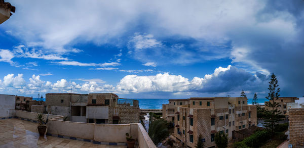 Panoramic view of city against cloudy sky