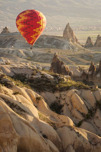 Hot air balloon flying over rocks