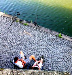 High angle view of people sitting by water