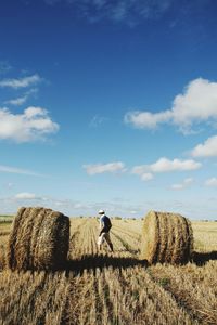 Hay bales on field against sky