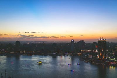 View of city at waterfront during sunset