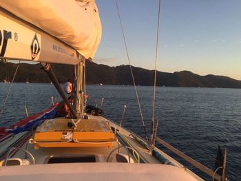 Boats sailing in sea against sky during sunset