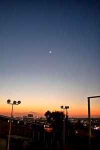 View of illuminated buildings against clear sky at sunset