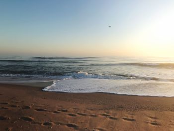 Scenic view of sea against clear sky during sunrise 