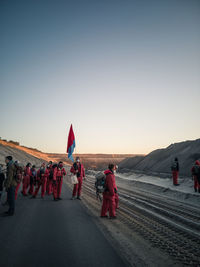 People walking on street against clear sky