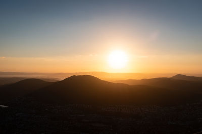 Scenic view of silhouette mountains against sky during sunset