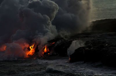 Lava on rocky shore with smoke at kilauea in hawaii