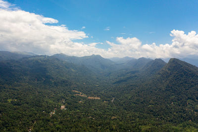 Mountains covered rainforest, trees and blue sky with clouds. sri lanka.