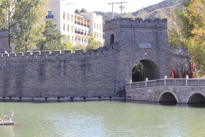 Arch bridge over river against buildings