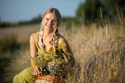 Portrait of young woman standing amidst plants