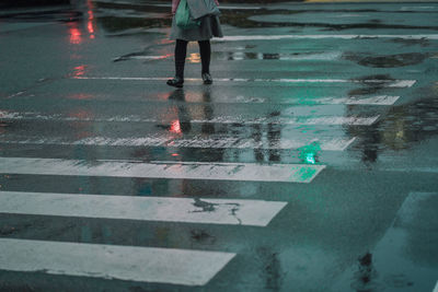 Low section of woman walking on crosswalk