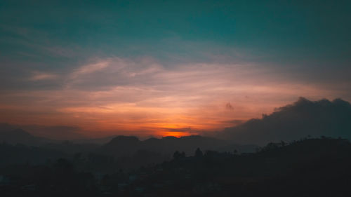 Scenic view of silhouette mountains against sky during sunset