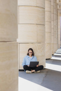 Portrait of young woman sitting on hardwood floor