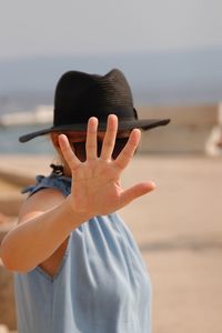 Woman showing stop gesture while standing at beach