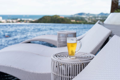 Glass of beer on rooftop swimming pool with city and sea view, hua hin, thailand. summer vacation